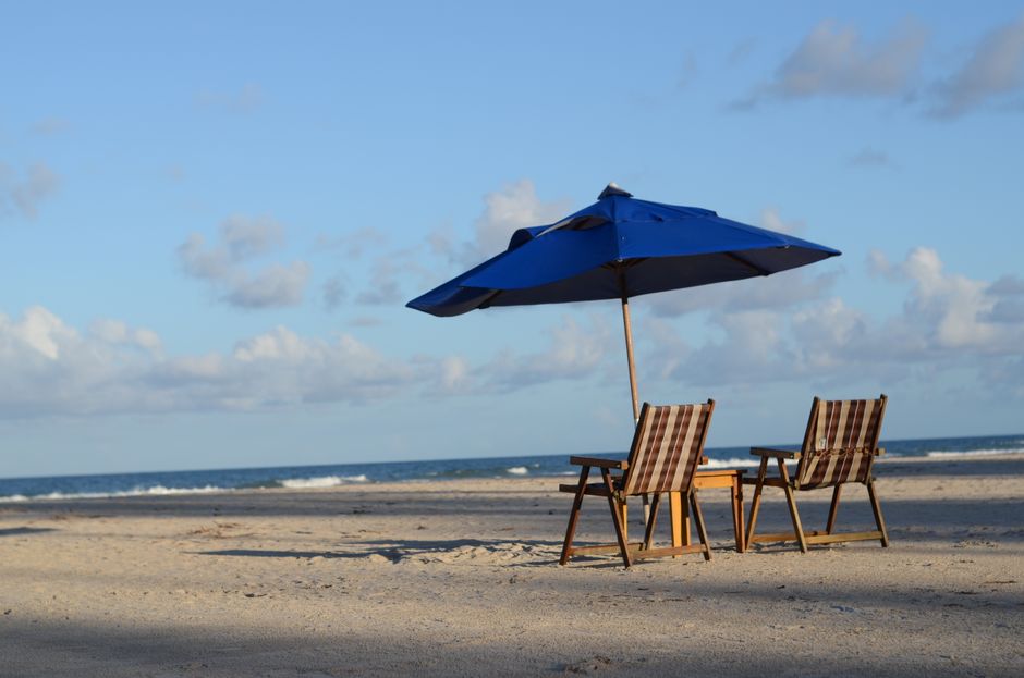 An empty deckchair on a quiet beach in soft afternoon light