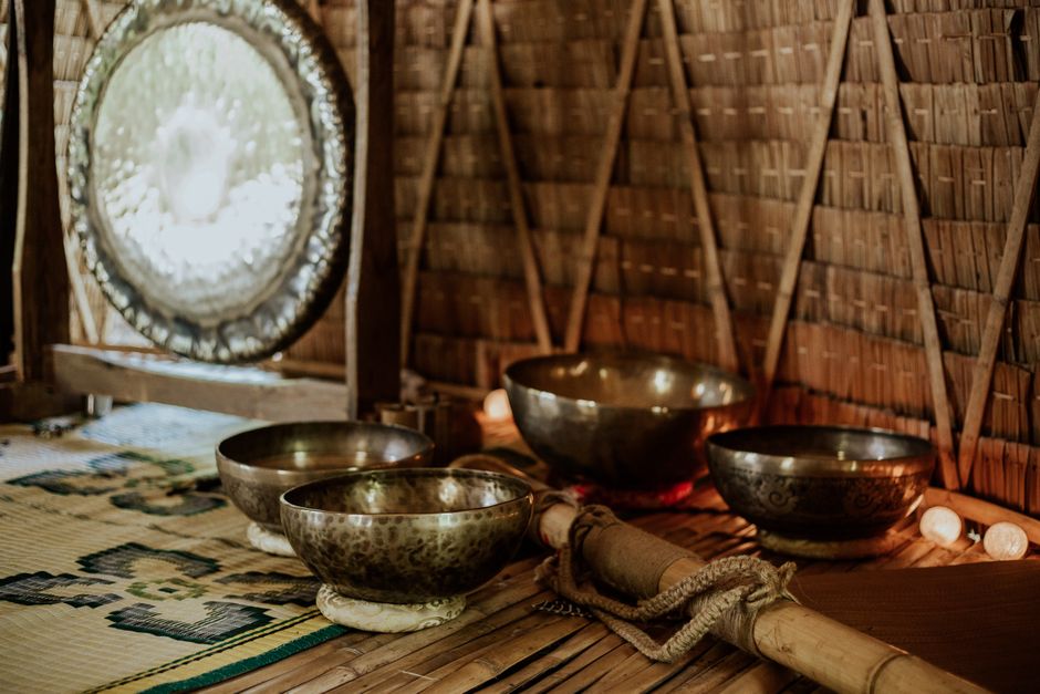 Singing bowls and other sound objects arranged on a wooden shelf in a calm shop