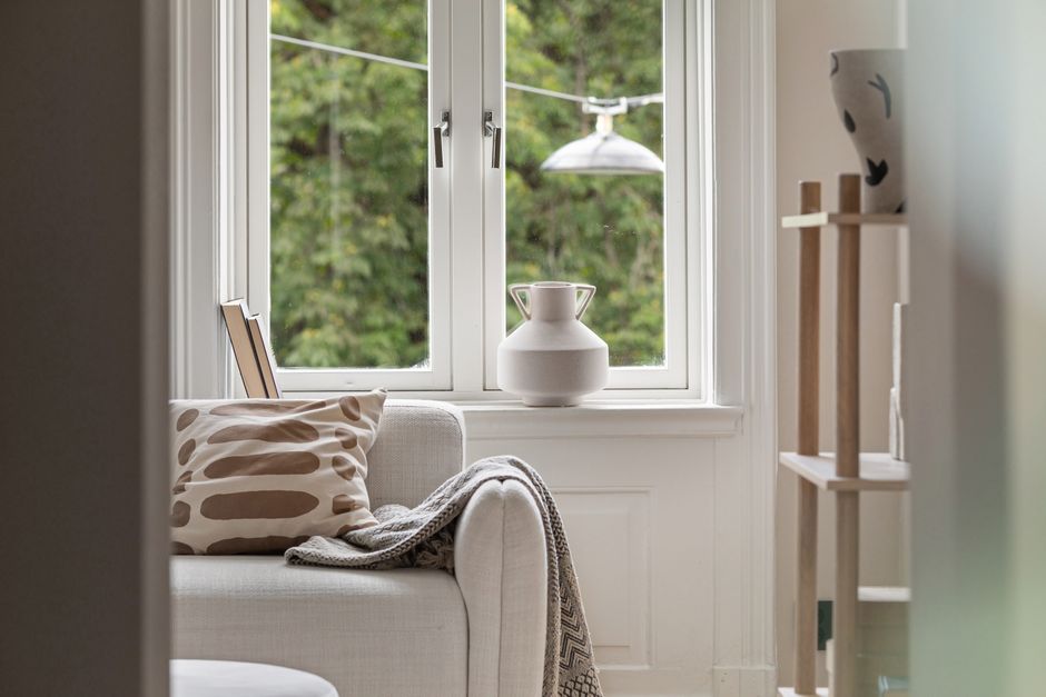 A quiet window corner set up with a soft blanket and warm light for unhurried rest